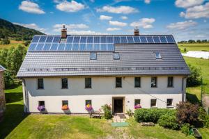 Biały dom z panelami słonecznymi na dachu w obiekcie Apartament Wielka Sowa w mieście Głuszyca Górna