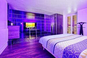 a purple bedroom with a bed and a fireplace at L'Eden d'Aphrodite in Grenoble +5 photos