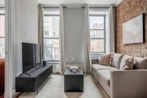 a living room with a couch and a tv at East Village 2br w wd nr groceries NYC-1221 in New York