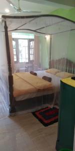 two beds in a room with a canopy bed at Jagabay Resort & Surfing School in Weligama