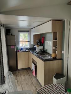 a kitchen with wooden cabinets and a counter top at MOBIL HOME in Piriac-sur-Mer