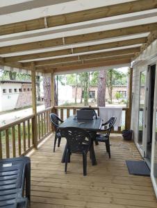 a patio with a table and chairs on a deck at MOBIL HOME in Piriac-sur-Mer