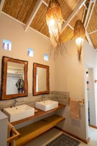 La salle de bains est pourvue de 2 lavabos et de 2 miroirs. dans l'établissement Bela Flor Beach Front Apartments, à Inhambane