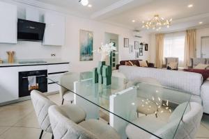 Adrich Properties East Legon في إيست ليغون: غرفة معيشة مع طاولة وكراسي زجاجية