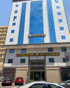 un gran edificio con coches estacionados frente a él en فندق الزائر, en La Meca