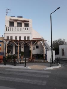 a white building on the corner of a street at THE HOUSE ON THE ROCK in Antimácheia