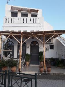 a wooden pergola in front of a white building at THE HOUSE ON THE ROCK in Antimácheia