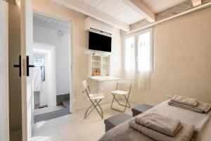 Un dormitorio con una cama y una mesa y sillas. en Â Chése De Menòple by STHEY, en Monopoli