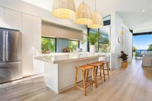 a kitchen with a large island with stools at Wanda in Suffolk Park