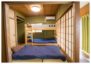 a small room with two bunk beds in it at I Love Matsuyama in Matsuyama