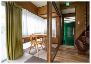 a dining room with a table and a green curtain at I Love Matsuyama in Matsuyama