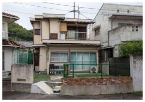 a house with a fence in front of it at I Love Matsuyama in Matsuyama