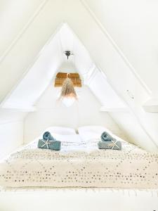 een slaapkamer met een bed op een witte zolder bij ELSK Cottage in Zandvoort