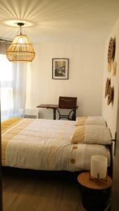 a bedroom with a bed and a table at Entre vignes et montagnes in Ayse