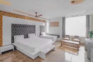 een slaapkamer met een groot wit bed en een bank bij Super OYO Hotel Vivaan Residency in Rohtak