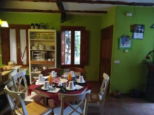 a dining room with a table and chairs and green walls at Una casa en el Planeta in Losana de Pirón