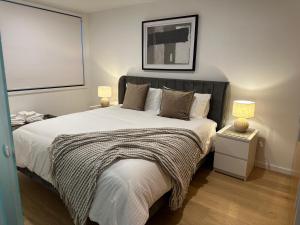 a bedroom with a large bed with a black headboard at Palko - Oasis in the City in Canberra