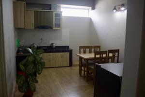 a kitchen and dining room with a table and a potted plant at Bergauf Apartment in Pokhara