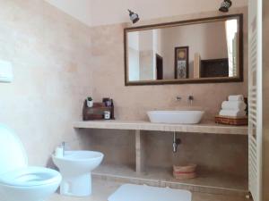 een badkamer met een wastafel, een toilet en een spiegel bij CASA Sweet HOME in Sulmona