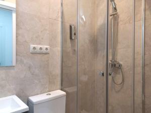 y baño con ducha, aseo y lavamanos. en Casa de Huéspedes 12 Octubre Rooms en Madrid