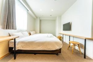 浦安市にあるCVSベイホテルのベッドとテレビが備わるホテルルームです。