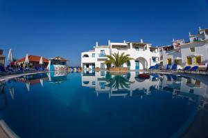 a swimming pool in front of some buildings at Viva Mare Foinikounta in Finikounta