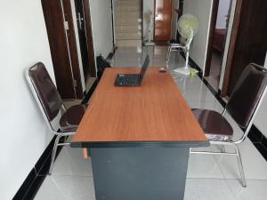 a conference table with a laptop on it with chairs at OYO 93085 Homy Stay Syariah in Balikpapan
