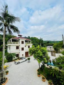 a white car parked in front of a building at KL Retreat Hotel in Thanh Hóa