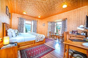a bedroom with a bed and a desk in a room at Shaw Inn by Stay Pattern in Gulmarg