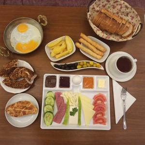 einen Tisch mit einem Tablett mit Eiern und Fleisch in der Unterkunft OLİVE GARDEN ANTALYA in Bahtılı
