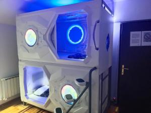 um quarto com uma máquina com três janelas redondas em panda Victor Space Capsule Hostel em Belgrado