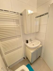 Baño blanco con lavabo y aseo en Family-friendly House in Vienna's Suburbs!, en Guntramsdorf