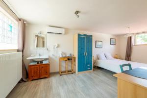 a bathroom with a bed and a sink in a room at Sarl Château Arago in Fauguerolles +8 photos