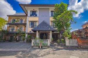 un bâtiment avec une clôture devant lui dans l'établissement Grand Santhi Hotel, à Denpasar