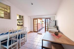 cocina y comedor con mesa y nevera en Casa da Cris, en São Paulo