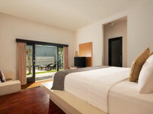 a bedroom with a large white bed and a patio at The Seminyak Suite - Private Villa in Seminyak