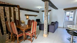 a dining room with a wooden table and chairs at La Tuilerie in Bèze