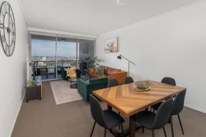 a dining room and living room with a table and chairs at AAB Apartments Skyline in Brisbane