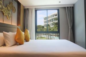 a bedroom with a large bed and a window at Wyndham La Vita Rawai Phuket in Rawai Beach
