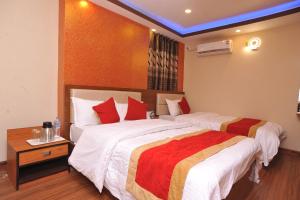 a hotel room with two beds with red pillows at Hotel Arati Pvt. Ltd. in Kathmandu