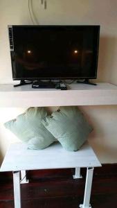 a television on a shelf with two pillows under it at บ้านปู in Ko Yao Noi
