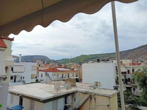 a view of a city from a balcony with an umbrella at Pnoe Luxury House in Nafplio
