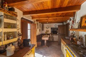 a kitchen with wooden ceilings and a stove top oven at L'Atelier du Temps - LE SECRET in Aosta
