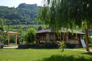 a house sitting in a yard with a tree at Domaćinstvo Una-Ostrovica in Kulen Vakuf