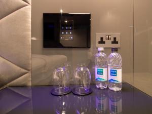 four bottles of water sitting on a glass table at Bloc Hotel London Gatwick Airport in Horley