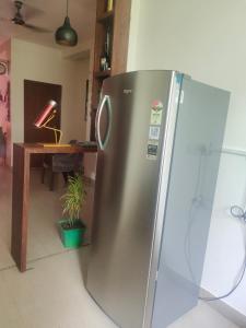 a stainless steel refrigerator in a kitchen with a table at Yb home in Sonīpat