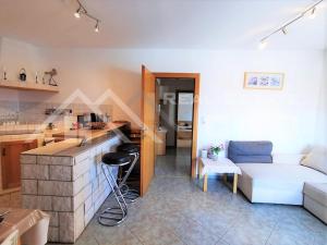 a living room with a white couch and a kitchen at Panoramablick in Trogir