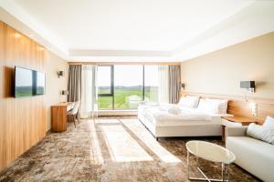 pokój hotelowy z łóżkiem i kanapą w obiekcie Blue&Green Baltic Hotel mediSPA&fit w Kołobrzegu