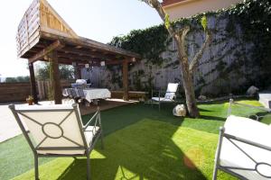 un patio trasero con una mesa y sillas sobre hierba en Catalunya Casas Indoor and Outdoor Pools, Sauna, Gym, Games Area, en Sant Pau dʼOrdal