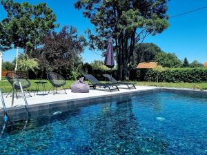 a person is sitting next to a swimming pool at Kuća mirne duše in Topola